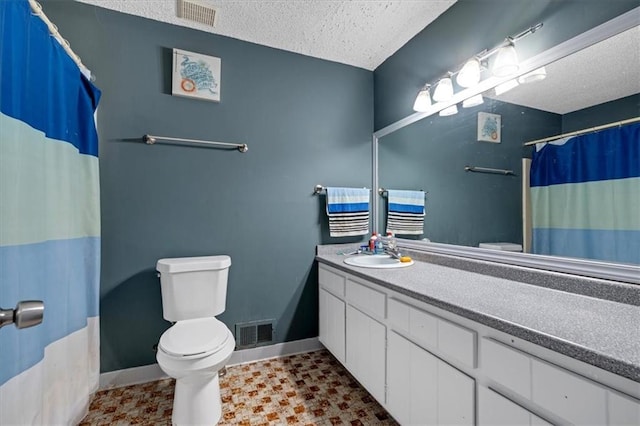 bathroom featuring a shower with curtain, vanity, toilet, and a textured ceiling