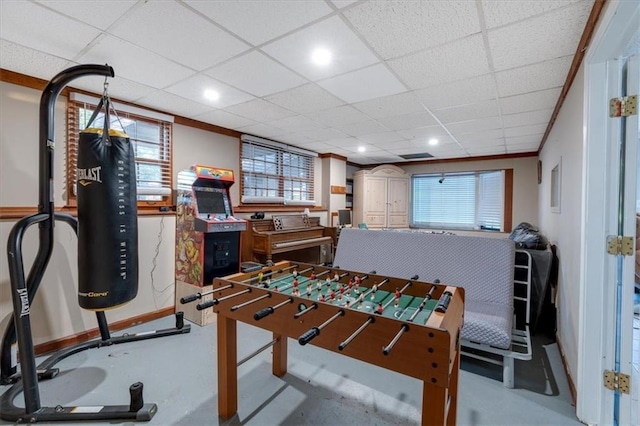 game room with a drop ceiling, ornamental molding, and a wealth of natural light