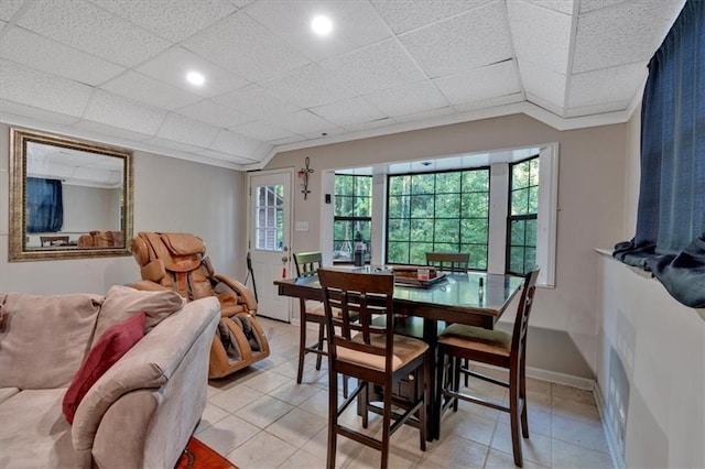 tiled dining space with a drop ceiling