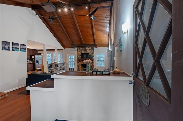 kitchen with hardwood / wood-style flooring, wooden ceiling, a fireplace, stainless steel fridge with ice dispenser, and beam ceiling