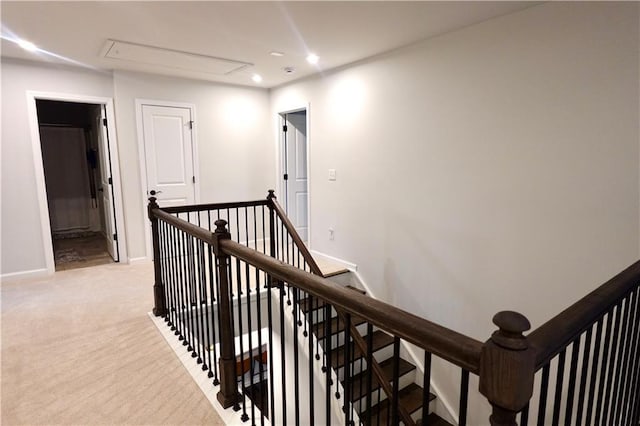 hall with an upstairs landing, recessed lighting, baseboards, light colored carpet, and attic access