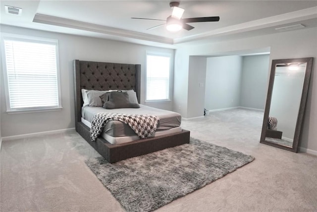 bedroom featuring visible vents, ceiling fan, baseboards, carpet, and a tray ceiling