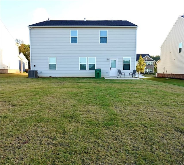 rear view of property with a patio, central AC, and a yard