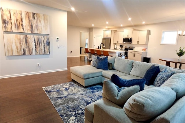 living area with dark wood-style floors, recessed lighting, and baseboards