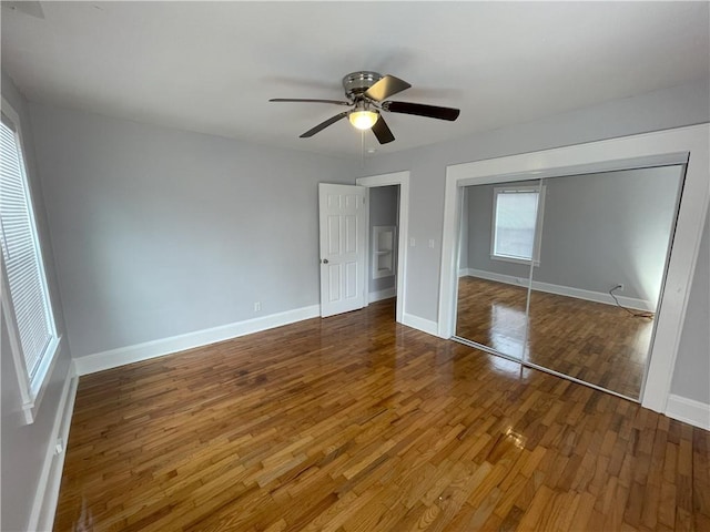 unfurnished bedroom with dark wood-type flooring, a closet, and ceiling fan