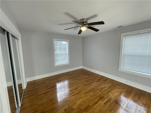 unfurnished bedroom featuring ceiling fan, dark hardwood / wood-style flooring, and a closet