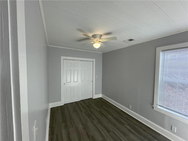 unfurnished bedroom with crown molding, ceiling fan, dark hardwood / wood-style floors, and a closet