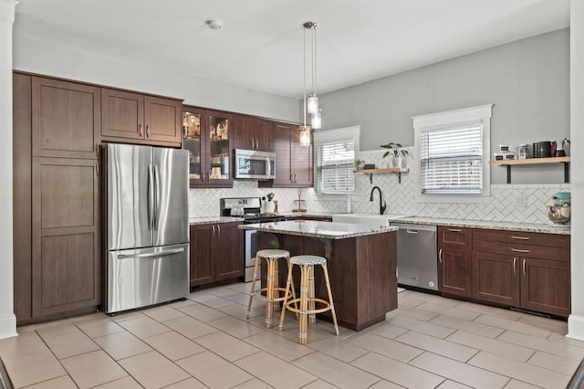 kitchen with stainless steel appliances, light tile floors, a kitchen bar, and backsplash