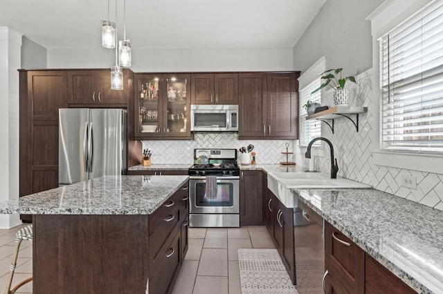 kitchen featuring appliances with stainless steel finishes, dark brown cabinetry, backsplash, and light tile floors