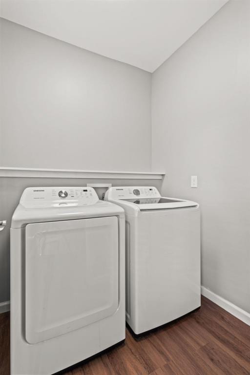 clothes washing area featuring washing machine and dryer and dark wood-type flooring