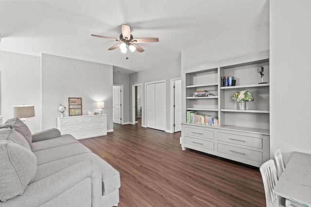 living room featuring ceiling fan and dark wood-type flooring