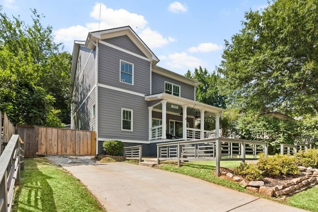 back of property with covered porch and a lawn