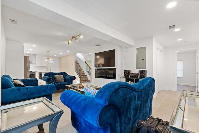 living room with electric panel and an inviting chandelier