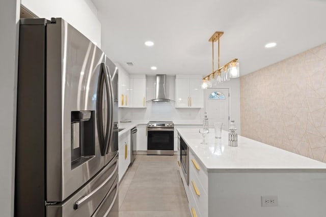 kitchen featuring stainless steel appliances, a center island, pendant lighting, white cabinetry, and wall chimney range hood