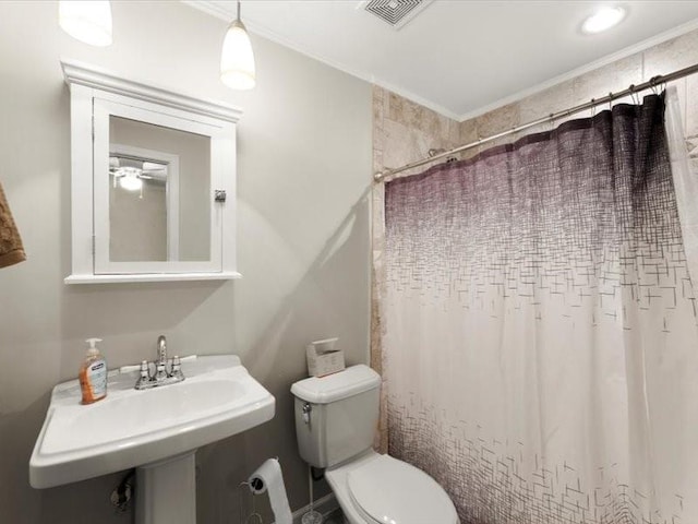 bathroom featuring walk in shower, toilet, sink, and ornamental molding