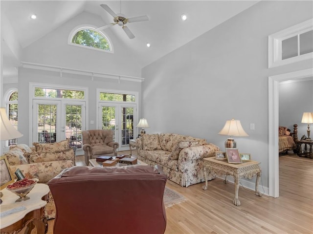 living area with high vaulted ceiling, ceiling fan, a healthy amount of sunlight, and french doors
