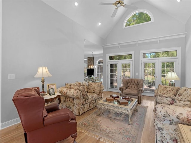 living area featuring recessed lighting, wood finished floors, french doors, high vaulted ceiling, and ceiling fan with notable chandelier