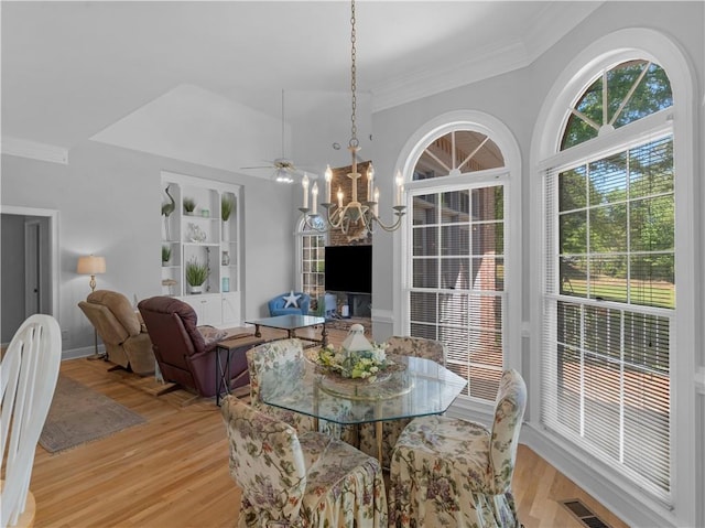 dining area featuring ornamental molding, light wood-style floors, visible vents, and ceiling fan with notable chandelier
