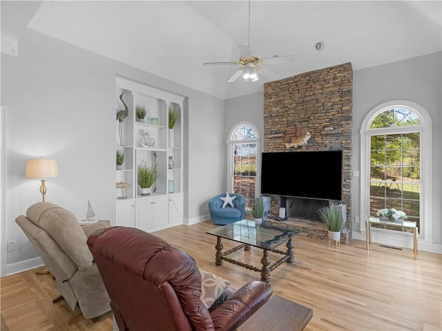 living room featuring wood finished floors, baseboards, and ceiling fan