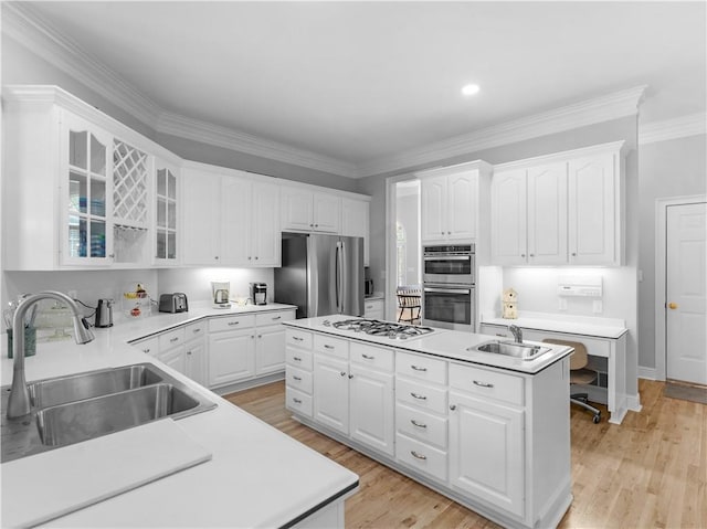 kitchen with white cabinets, an island with sink, stainless steel appliances, and a sink