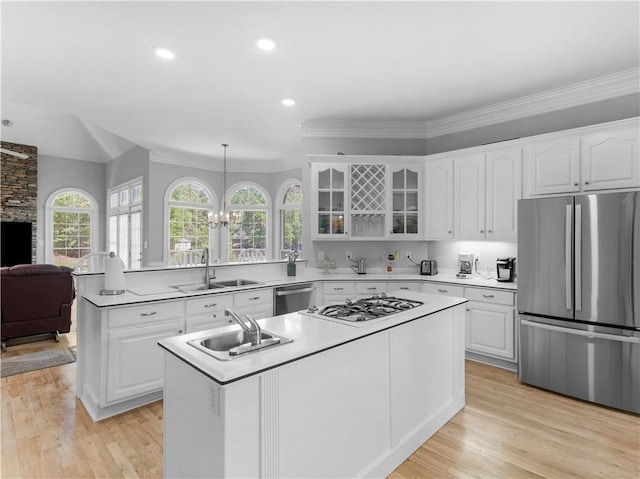 kitchen with glass insert cabinets, white cabinetry, stainless steel appliances, and a sink