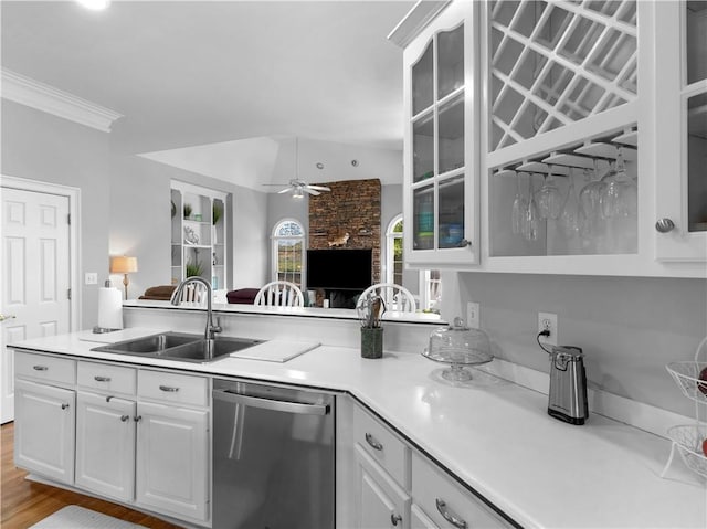 kitchen featuring stainless steel dishwasher, a sink, open floor plan, glass insert cabinets, and ceiling fan