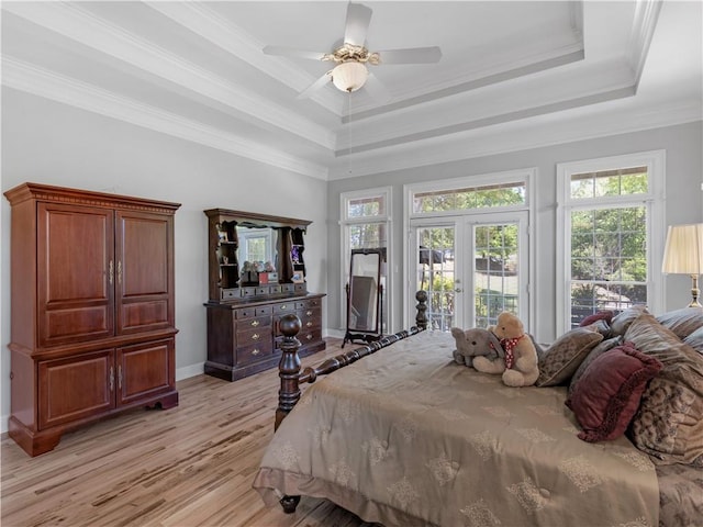 bedroom with a tray ceiling, access to exterior, a ceiling fan, baseboards, and light wood-style flooring