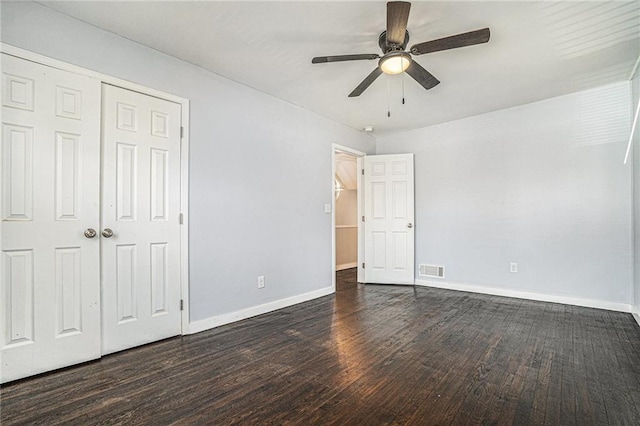 unfurnished bedroom featuring baseboards, visible vents, a ceiling fan, dark wood-type flooring, and a closet