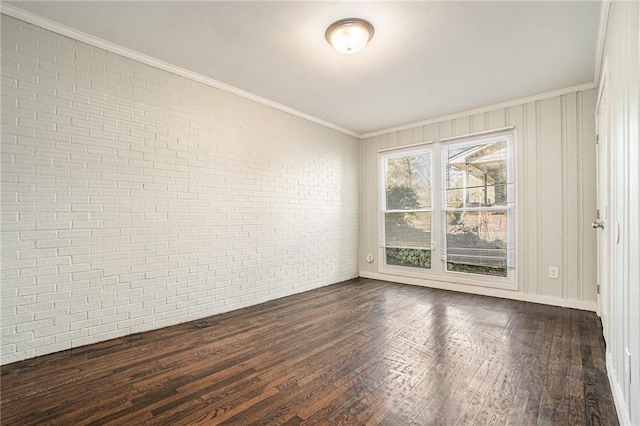 empty room featuring brick wall, ornamental molding, and dark wood finished floors
