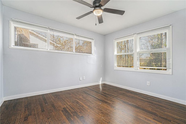 unfurnished room with ceiling fan, dark wood finished floors, and baseboards