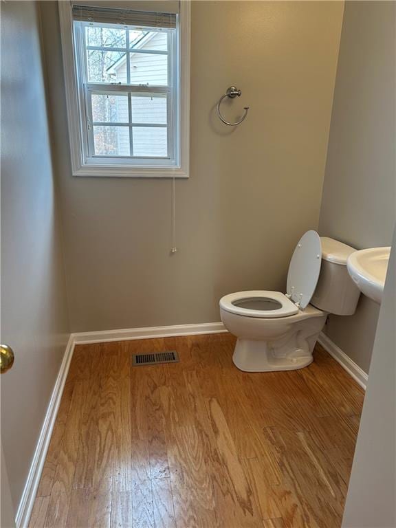 bathroom featuring wood-type flooring, sink, and toilet