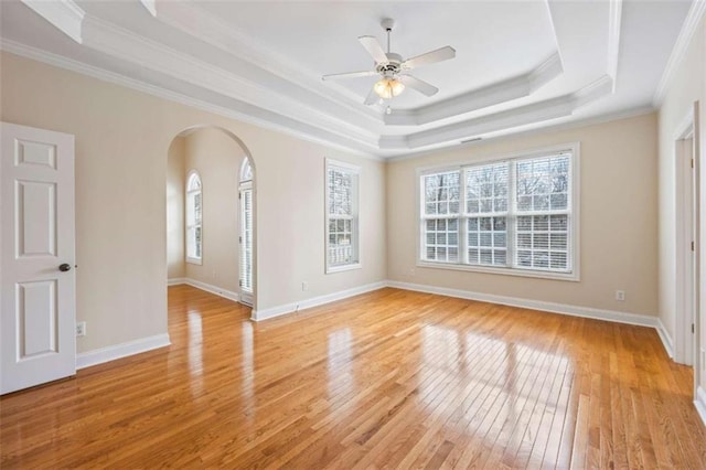 unfurnished room featuring ceiling fan, ornamental molding, a raised ceiling, and light hardwood / wood-style floors