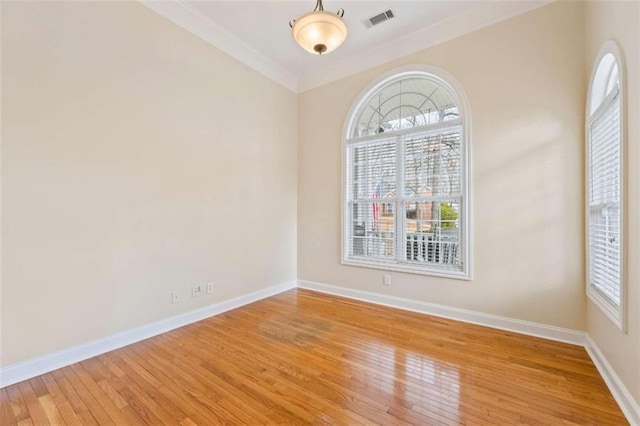 spare room featuring crown molding and light hardwood / wood-style flooring