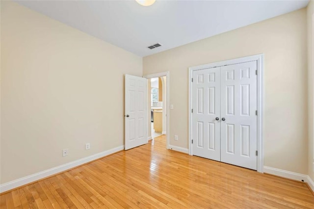 unfurnished bedroom featuring a closet and light wood-type flooring