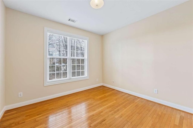 unfurnished room with hardwood / wood-style flooring