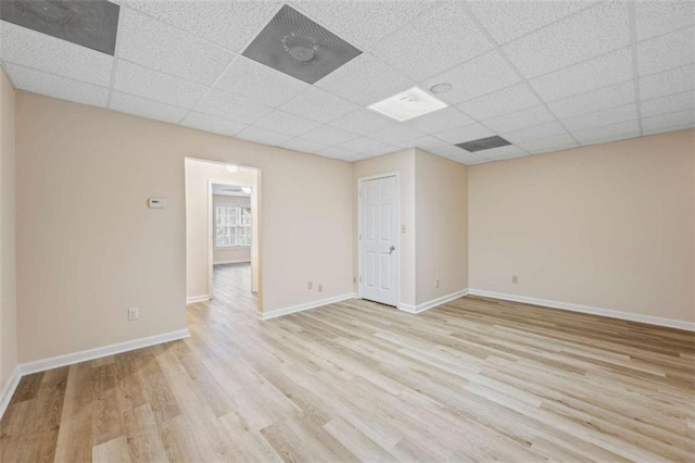 spare room with light hardwood / wood-style floors and a drop ceiling