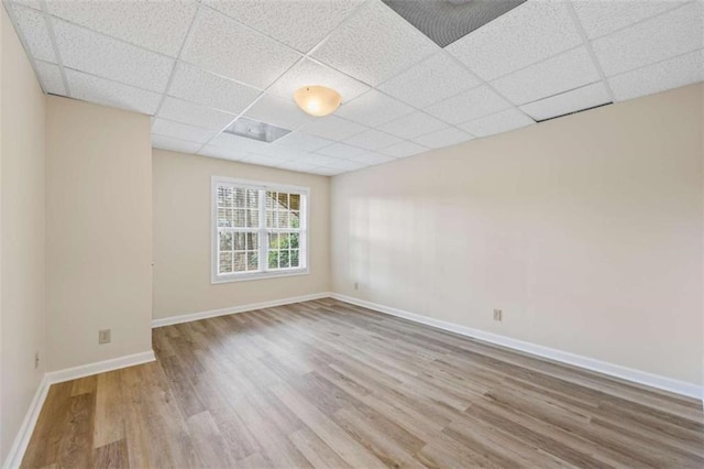 unfurnished room with a paneled ceiling and hardwood / wood-style floors