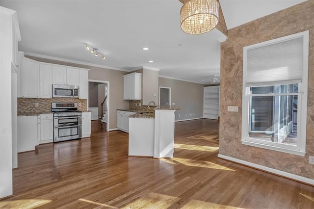 kitchen featuring white cabinetry, appliances with stainless steel finishes, and kitchen peninsula