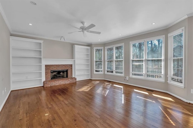 unfurnished living room featuring hardwood / wood-style floors, built in shelves, a fireplace, and ceiling fan