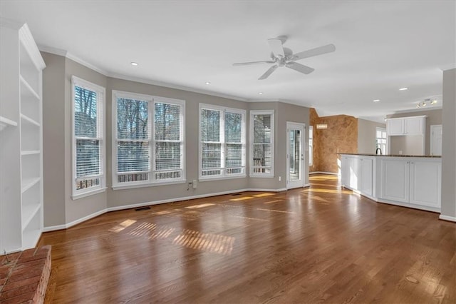 unfurnished living room featuring crown molding, dark wood-type flooring, and ceiling fan