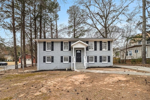 raised ranch with brick siding and fence