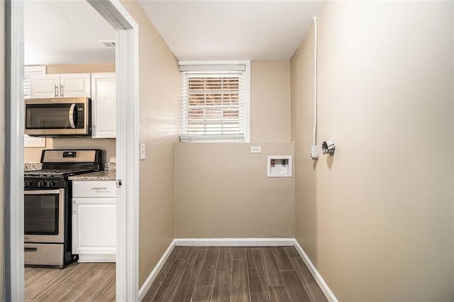 laundry room featuring laundry area, dark wood-type flooring, washer hookup, and baseboards