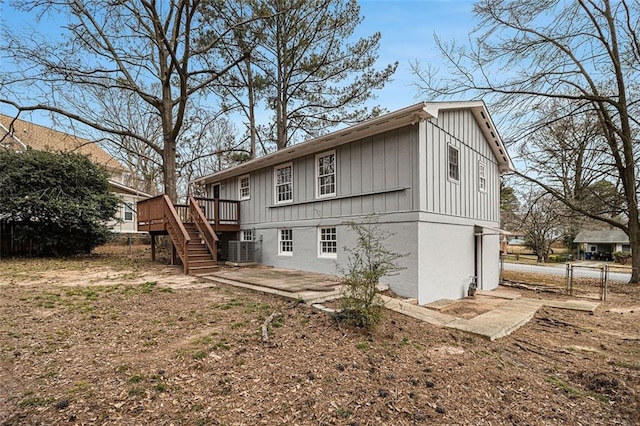 rear view of property with a deck, a patio, central AC unit, fence, and stairway