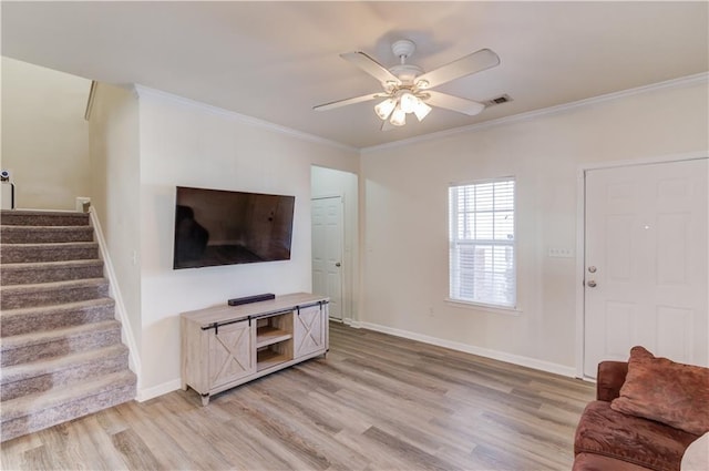 living room featuring ornamental molding, light wood-style floors, and stairway