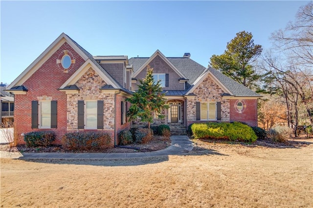 view of front of house featuring stone siding, a front yard, and brick siding