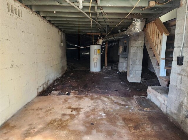 basement featuring electric panel and electric water heater