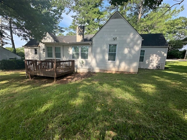 rear view of house with a lawn and a deck