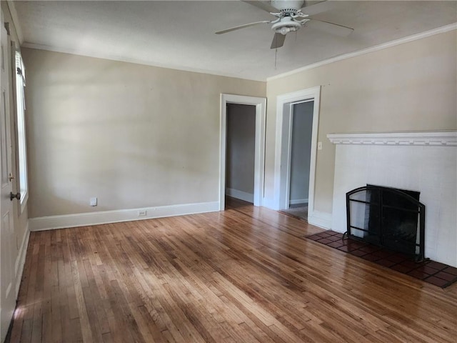 unfurnished living room with a fireplace, dark hardwood / wood-style flooring, ornamental molding, and ceiling fan