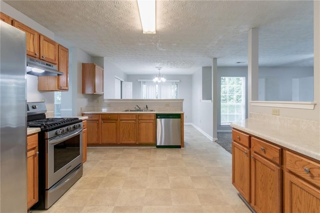 2191 Phillips Rd, Lithonia, GA 30058 - kitchen featuring appliances with stainless steel finishes, under cabinet range hood, a sink, a peninsula, and light countertops