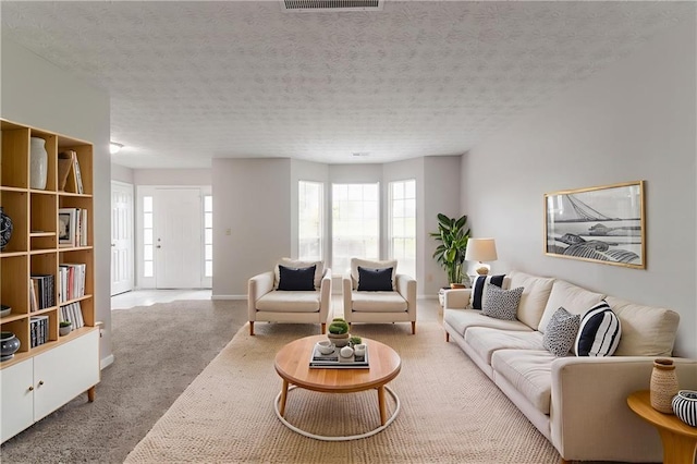 2191 Phillips Rd, Lithonia, GA 30058 - carpeted living room featuring healthy amount of natural light, a textured ceiling, and baseboards
